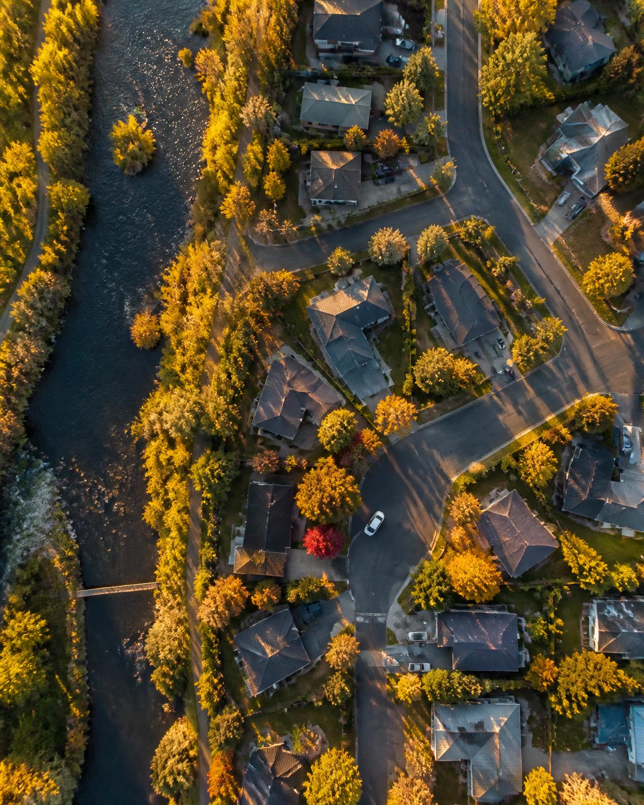 Overhead drone photograph of a riverfront Bend, Oregon neighborhood in autumn