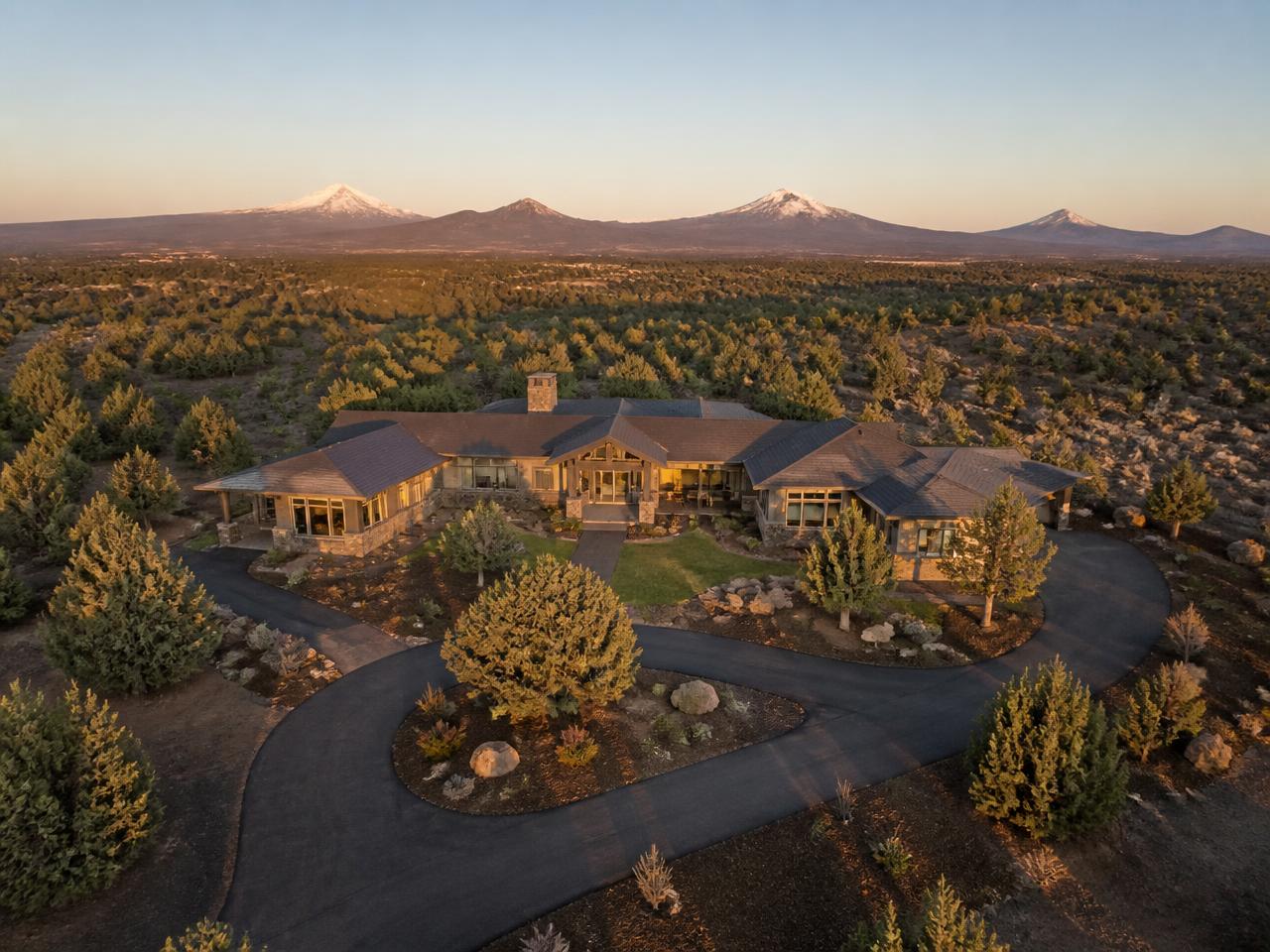 Aerial drone photo of a Central Oregon home on acreage with the Cascade peaks beyond